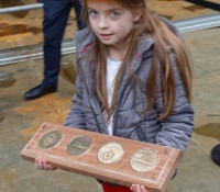 Elea, Tochter des Schiffsarchitekten, trägt die Glücksmünzen aufs Schiff