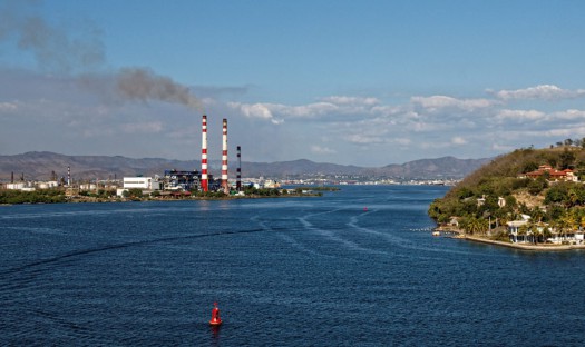 Qualmende Raffinerie an der Hafenausfahrt von Santiago de Cuba