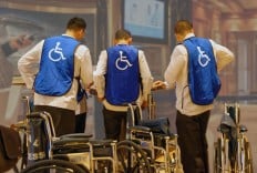 Crewmitglieder stehen für die Unterstützung von Rollstuhlfahrern bereit.