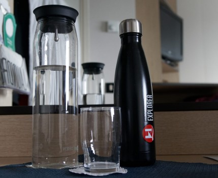 Becher und Karaffe aus Glas, Trinkflasche auf Metall - bei Hurtigruten.