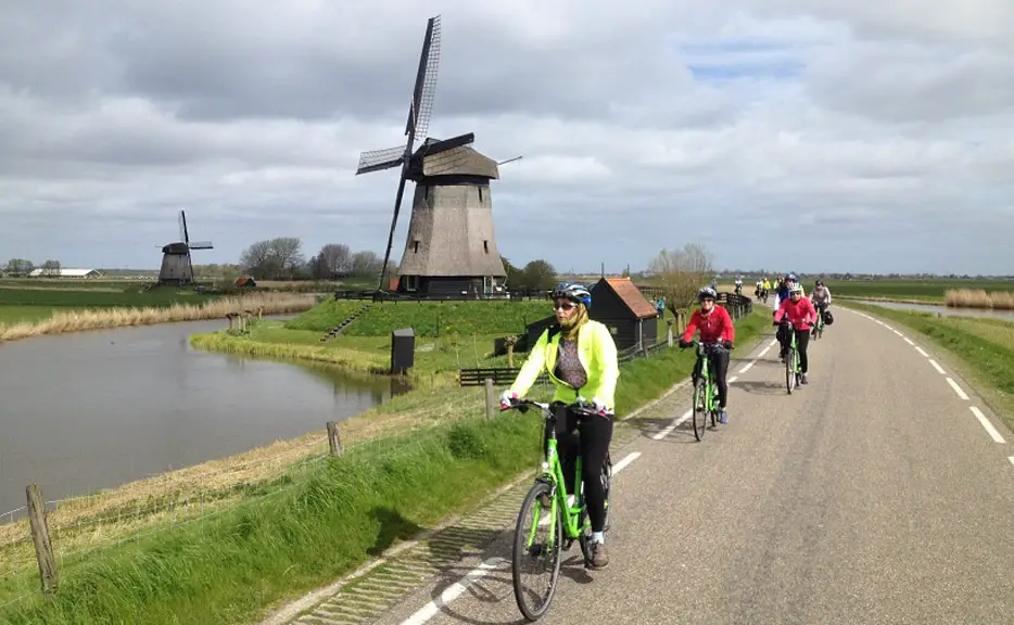 Radfahrer und Windmühlen (Bild: Boat Bike Tours)