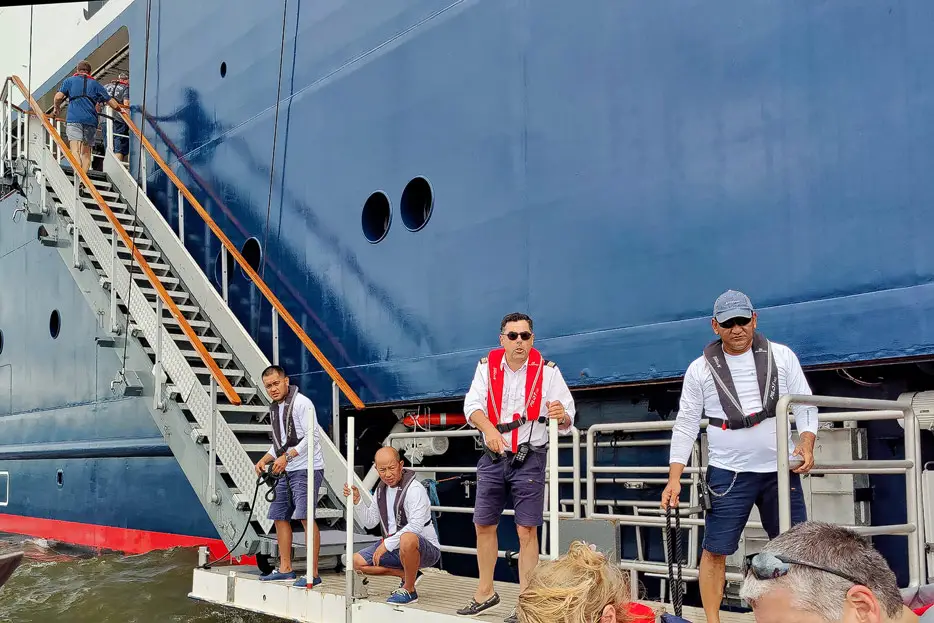 Kapitän und Crew an der Gangway bei Rückkehr eines Zdiac zum Schiff