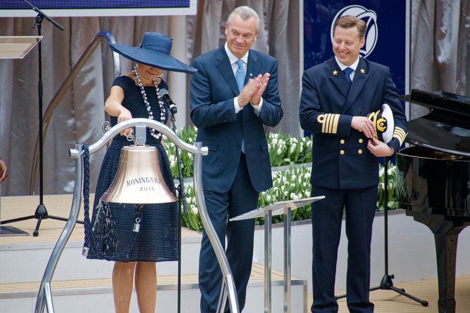 Dem alten Brauche, Wein am Schiffsdeck zu vergießen, kommt die Taufe der Koningsdam 20. Mai 2016 in Rotterdam durch Königin Maxima der Niederlande schon recht nahe: Sie taufte das Schiff, indem sie am Pooldeck ein Glas Champagner über die Schiffglocke goss.